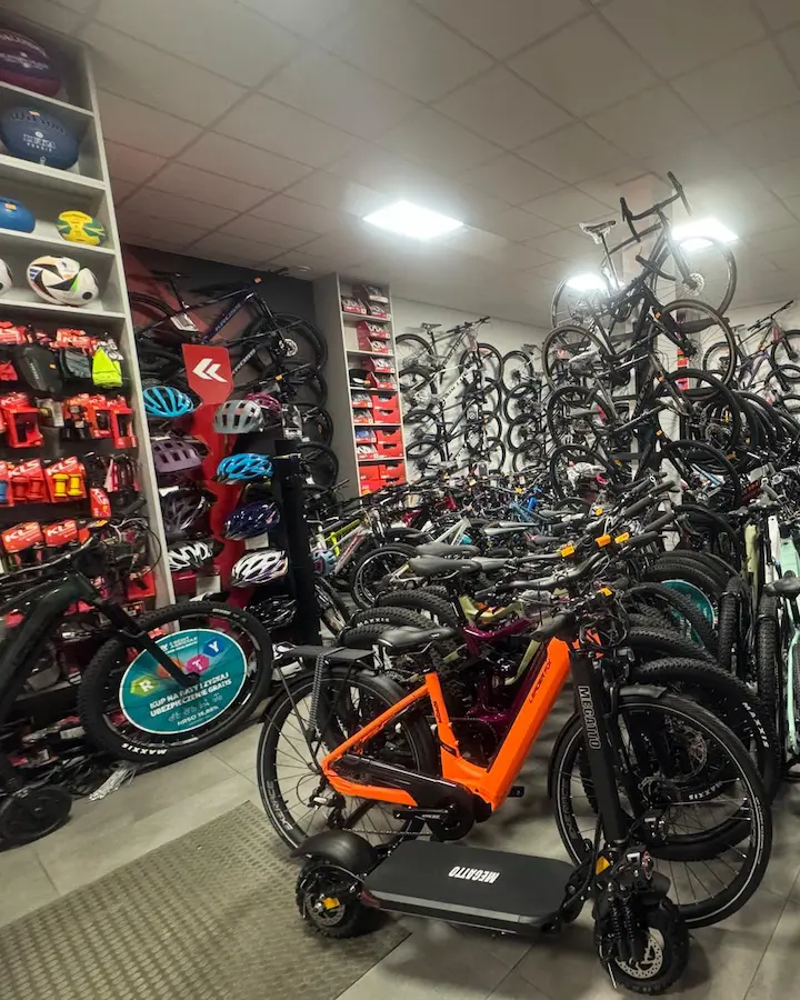Wnętrze sklepu rowerowego Brylant w Tuchowie — ekspozycja rowerów górskich i miejskich oraz ściana pełna akcesoriów rowerowych