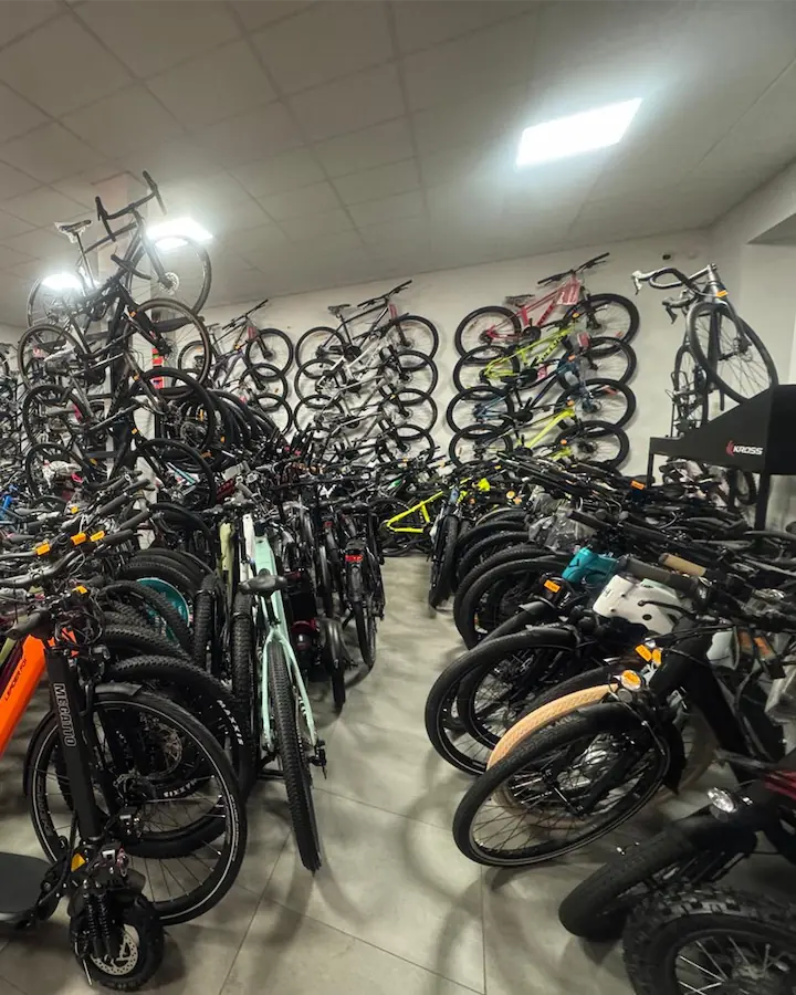 Wnętrze salonu rowerowego Brylant w Tuchowie — rowery na podłodze i zawieszone na ściennej ekspozycji autoryzowanego dealera KROSS
